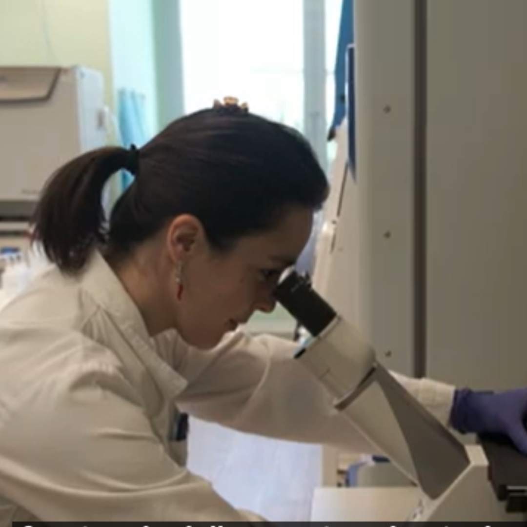 Una ricercatrice al lavoro in un laboratorio di elettrofisiologia, tra microscopio e strumentazione: la ricerca sulle canalopatie muscolari e le miotonie non distrofiche